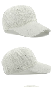 Detail of white cable knit baseball cap with silver sequins and mesh texture