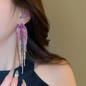 Close-up of elegant gradient purple tassel earrings with rhinestones on a female model