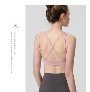 Detail of light pink sports bra with minimalist crisscross back straps for yoga