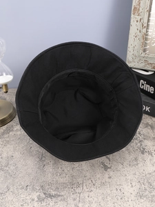 Detailed interior view of a black foldable bucket hat showing the sweatband and stitching