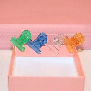 Close-up of four colorful heart-shaped plastic clips in green blue clear and orange