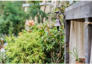 Close-up of vintage cast iron doorbell featuring bird and leaf accents for garden decor