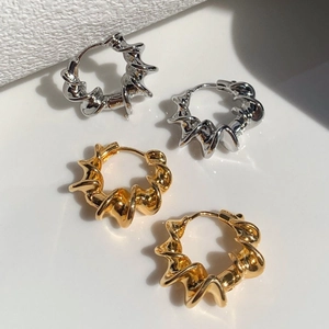 Modern twisted geometric hoop earrings in gold and silver finish on white background