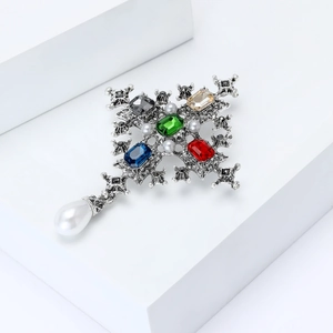 Baroque cross brooch with colorful gemstones and hanging teardrop pearl detail