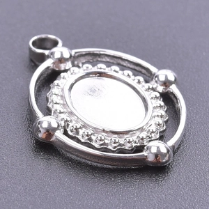 Close-up of silver stainless steel oval pendant setting with beaded edges and round accents