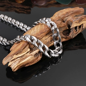 Collier gourmette en acier inoxydable argenté poli enroulé sur bois vieilli