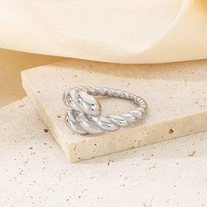 Detail view of silver twisted rope ring in polished stainless steel on marble