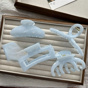 Five-piece blue ink-painted acetate hair claw clip set displayed in a premium jewelry tray