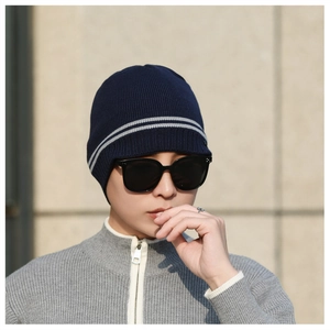 Outdoor shot of a navy blue ribbed knit winter beanie with grey stripe details for men