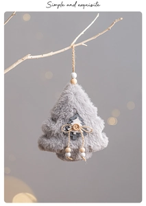 Gray plush Christmas tree ornament with wooden button and twine hanging on a branch