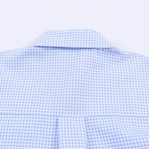 Detailed view of blue and white plaid shirt fabric showing precise stitching on the collar