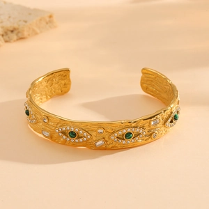 Macro detail of gold hammered cuff bracelet with malachite evil eye and pavé crystals