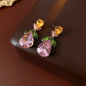 Macro shot of colorful zircon drop earrings with pink water drop and green leaf gems