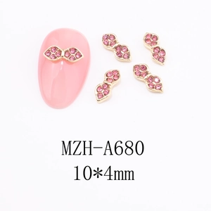 Macro view of gold bow nail charms with pink rhinestones and 10x4mm size detail