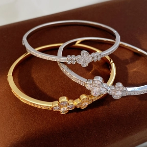 Macro shot of silver and gold clover bangles with pavé-set cubic zirconia crystals