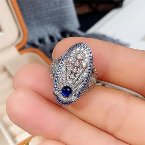 Anillo vintage de plata calada con zafiro azul y piedras de circón blanco en una caja