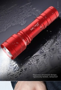 Waterproof red aluminum flashlight on water-splashed black surface showing durability