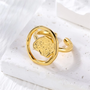 Close-up of golden irregular open ring with textured hammered pattern on stone base
