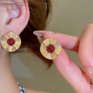 Retro-Ohrstecker aus Gold mit konzentrischer Rippelstruktur und roter Harzperle