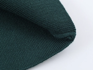 Detailed close-up showing the dark green ribbed knit texture of the sweater shoulder bow