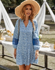 Close-up of blue floral dress featuring V-neck buttons and lace stitching on sleeves