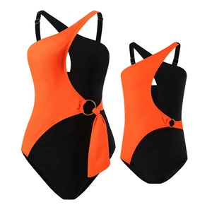 Matching parent and child one-shoulder swimsuits in vibrant orange and black color block