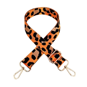 Detail of leopard print nylon strap with gold metal hooks and thick woven texture