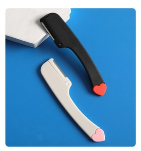Detail of mini facial razors with heart accents in black and white on blue background