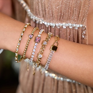 Gold heart bracelet set with pink gemstones and white zircon on female wrist