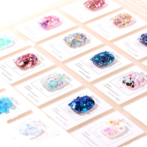Mix of colorful hexagonal nail art sequins and holographic glitter sets on display cards