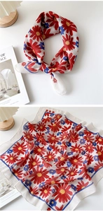 Detail of floral linen neckerchief with red daisy print and blue border accents