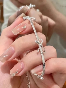 Detailed close-up of a silver bow blade chain bracelet with adjustable clasp for women