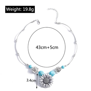 Detail view of sunflower necklace with blue turquoise beads and Viking pattern carving