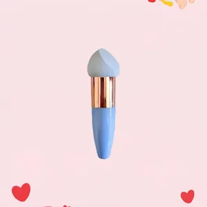 Detail of blue makeup brush with rose gold ferrule and grey slanted sponge tip