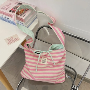 Vue détaillée du sac cabas rayé en toile avec doublure vert menthe et nœud décoratif