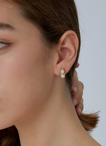 Detail of a Christmas snowman earring featuring white pearls and gold metal accents