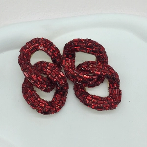 Detail of red rhinestone chain earrings showing double interlocking loops and gold base