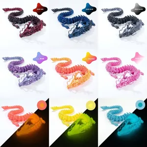 3D printed articulated dragon ornaments in various colors with glow-in-the-dark effects