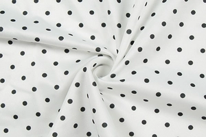 Macro shot of white polka dot fabric with soft texture and elegant draped folds