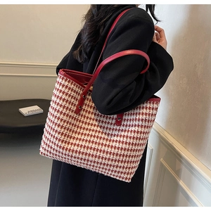 Detail of red houndstooth tote bag featuring premium leather handles and large capacity