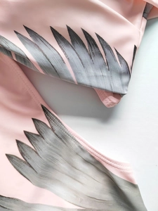 Detail of pink swimwear fabric with grey feather print and high-quality flatlock stitching