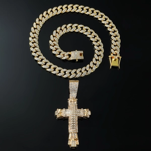 Close-up of golden iced-out cross pendant with shimmering cubic zirconia on Cuban chain