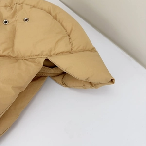 Close-up of khaki quilted down hat fabric featuring neat stitching and metal eyelet detail