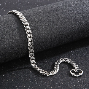 Gros plan sur un bracelet gourmette en acier titane argenté avec fermoir coeur et éclat métal
