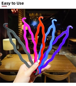 Close-up of colorful wave-shaped plastic hair styling tools in five vibrant colors
