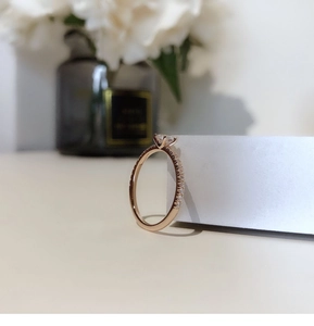 Detailed side view of rose gold sugar cube ring with micro-pave diamonds and round center stone