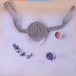 Detailed close-up of handmade grey crochet nose warmer with spiral knitted pattern straps