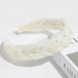 Detailed view of braided white mesh headband with pearls for an elegant vintage hair look