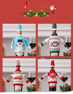Close-up of knitted Christmas wine bottle covers with snowman and car motifs
