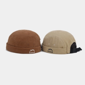 Detail of caramel suede and khaki canvas docker hats with RAHHSR mountain embroidery